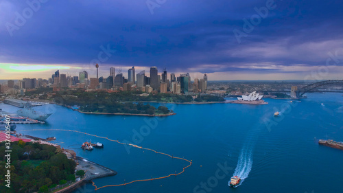 Panoramic drone aerial view over Sydney harbour on a cloudy sunset showing the nice colours of the CBD aparments and officer towers