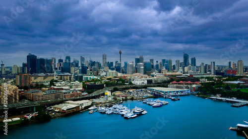 Panoramic drone aerial view over Sydney harbour on a cloudy sunset showing the nice colours of the CBD aparments and officer towers © Elias Bitar