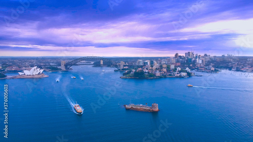 Panoramic drone aerial view over Sydney harbour on a cloudy sunset showing the nice colours of the CBD aparments and officer towers