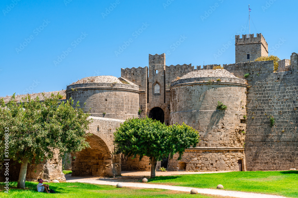 View of the medieval city walls and the moat, the d'Amboise Gate and the Palace of the Grand master, in Rhodes Island, Greece.