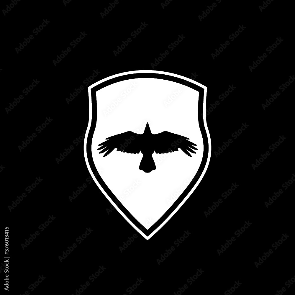 Raven bird and heraldic shield icon isolated on dark background Raven bird and heraldic shield icon isolated on dark background