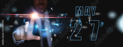 may 27th. Day 27 of month,advertising or high-tech calendar, man in suit presses bright virtual button spring month, day of the year concept
