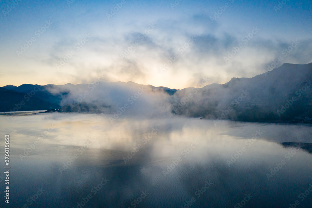 Fototapeta premium Lovely autumnal landscape with fog over the lake.