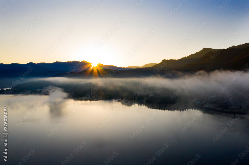 Fototapeta premium Lovely autumnal landscape with fog over the lake.