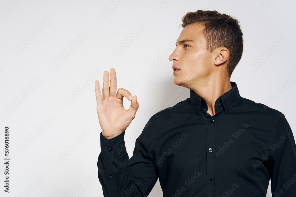 Man in black shirt lifestyle emotions modern style cropped view light background Man in black shirt lifestyle emotions modern style cropped view light background