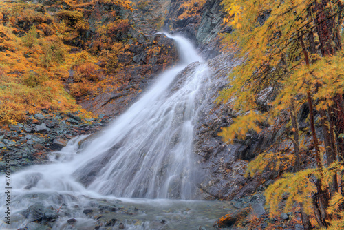 Beautiful waterfall in the autumn forest. Soft focus. Long exposure photo of flowing water.