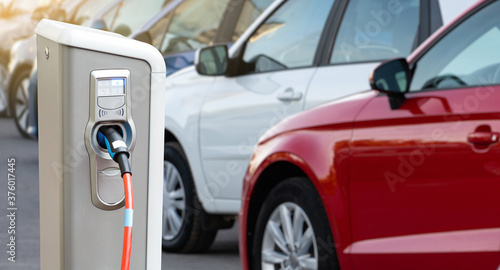 Close-up of a electric charging station on the background of cars