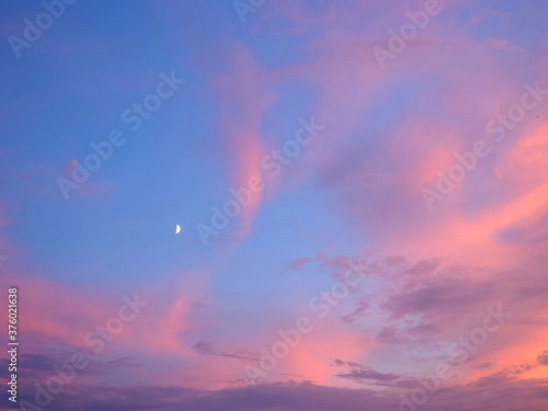 Bright sky illuminated by pink sunset light as background and texture. © Sergey