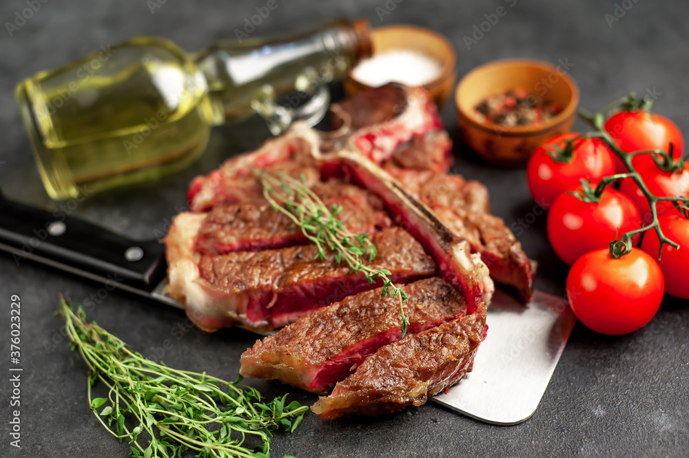 grill t-bone steak with ingredients on a meat knife on stone background