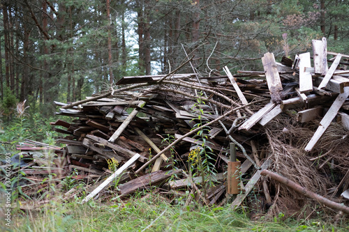 Fototapeta Naklejka Na Ścianę i Meble -  Old broken building materials in nature, demolition waste. Huge pile of construction waste stacked in the forest waiting to be burnt, recycled