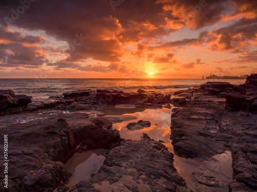 Golden Seaside Sunrise with Rockpool Reflections and Crashing Waves