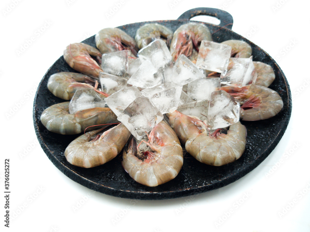 Top view of fresh prawns on a black plate with ice, selective focus.white background. Top view of fresh prawns on a black plate with ice, selective focus.white background.