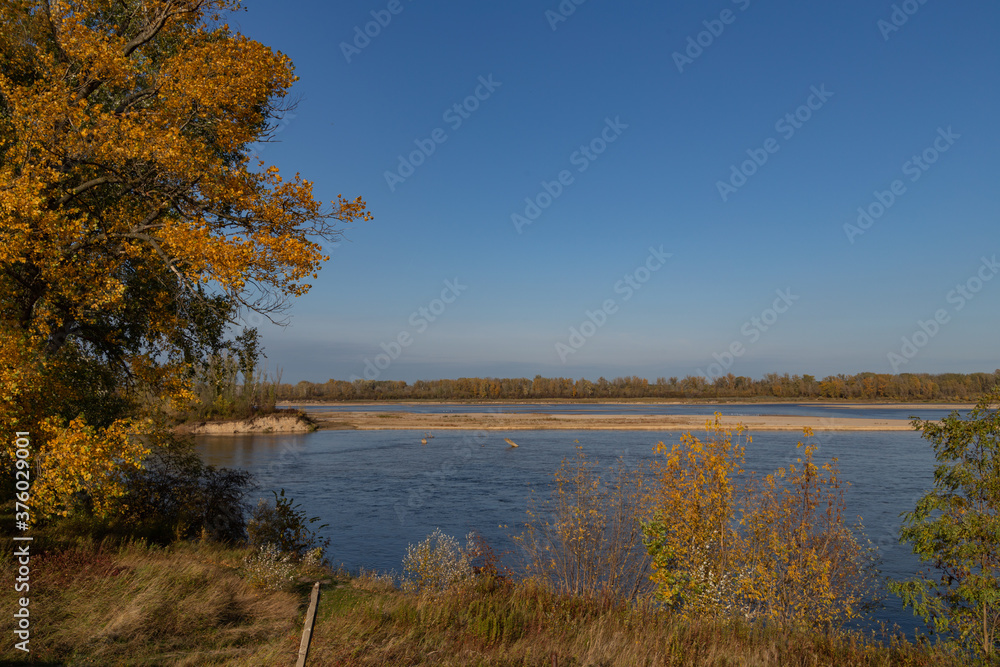 view of the Vistula river with blue water on a background of blue sky in autumn