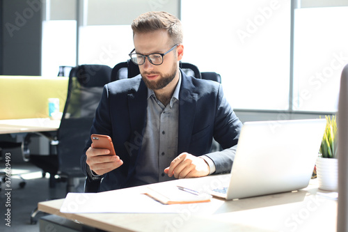 Wallpaper Mural Businessman using his mobile phone in the office. Torontodigital.ca