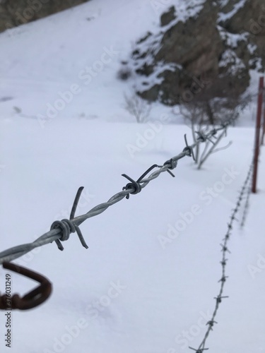 barbed wire in the mountain covered with white snow