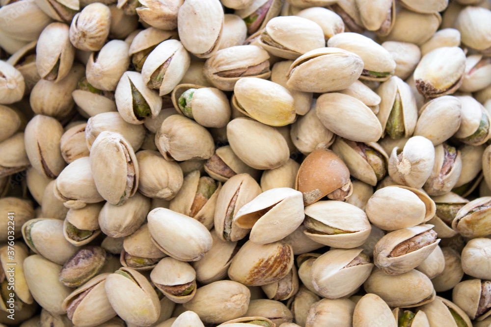 Pistachios are scattered on the table. Background for design
