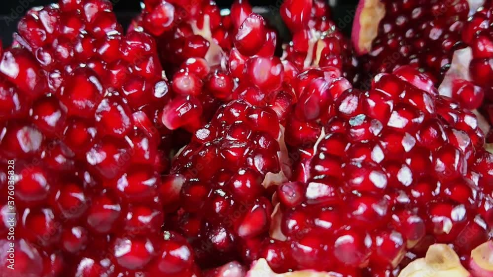 Grains of ripe pomegranate are falling on the surface of broken pomegranate in slow motion Grains of ripe pomegranate are falling on the surface of broken pomegranate in slow motion