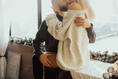 Obraz na płótnie Young couple of man and woman in casual clothes, sitting on windowsill and passionately hugging. Woman and man enjoying perfect relationships w salonie