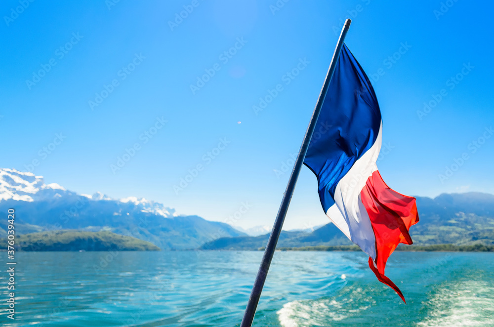 Φωτογραφία French flag on the background of the French alps surrounding Lake Annecy