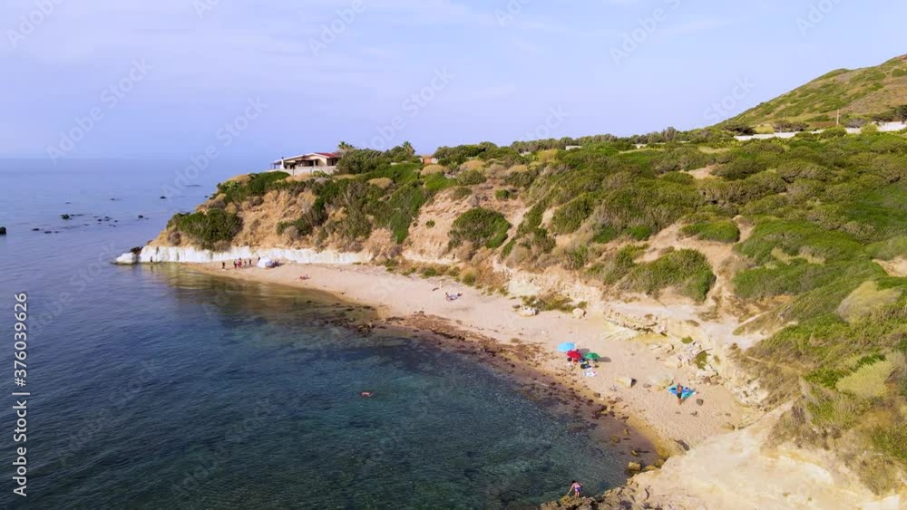 Tracking shot aerial drone view of coastline with people sunbathing and relaxing in Sardinia, Italy Tracking shot aerial drone view of coastline with people sunbathing and relaxing in Sardinia, Italy