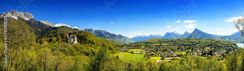 Wide pastoral view of  Alps, hills, meadows and villages surrounding Lake Annecy. View of the Castle of Menthon-Saint-Bernard (Château de Menthon-Saint-Bernard)