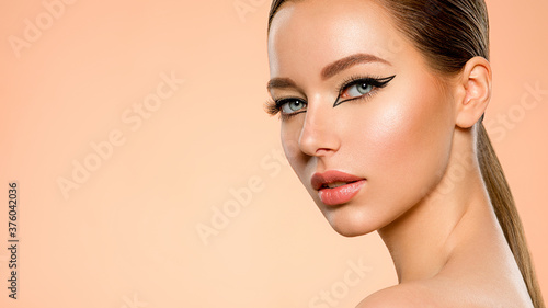 Beautiful girl with makeup in the form of arrows. Face of a young girl close-up with fashionable makeup. Stylish makeup.