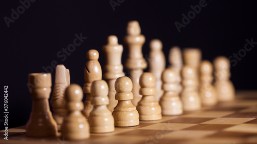 Wooden chess in a contrasting light. A game of chess, an intellectual competition,