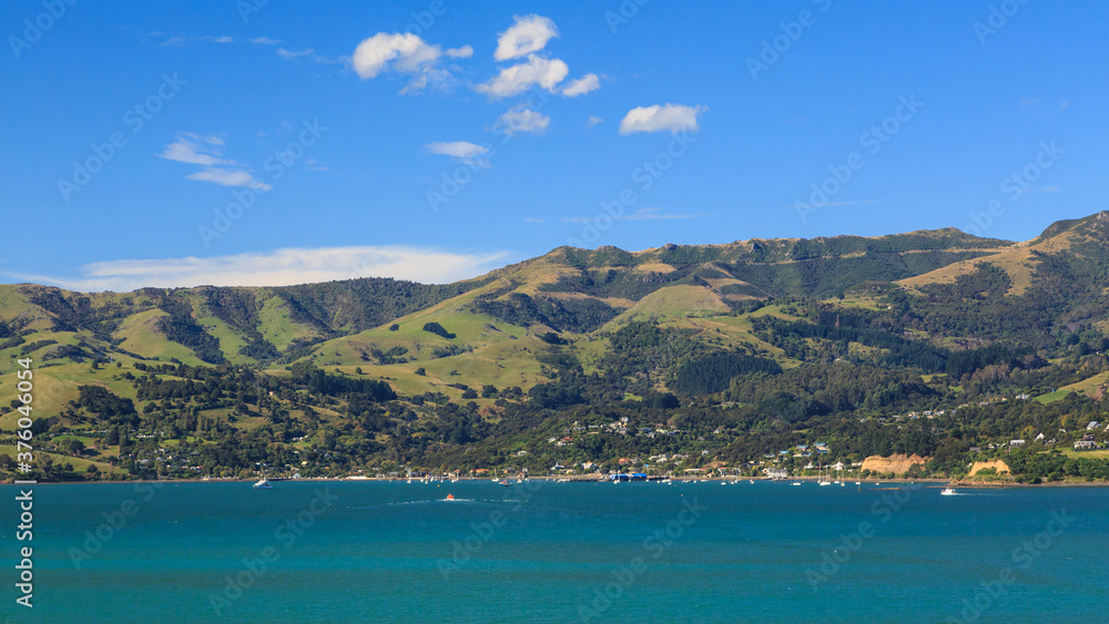 Panoramic view of the town of Akaroa, New Zealand, and the surrounding hills, seen from the harbor