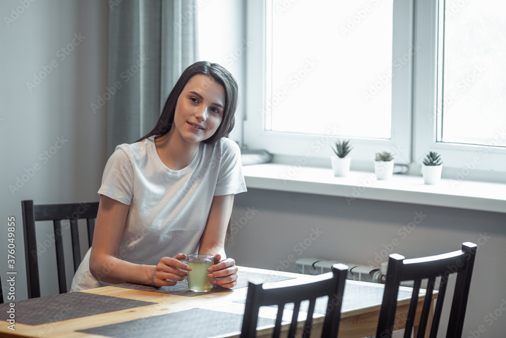 beautiful young woman drinking hot beverage