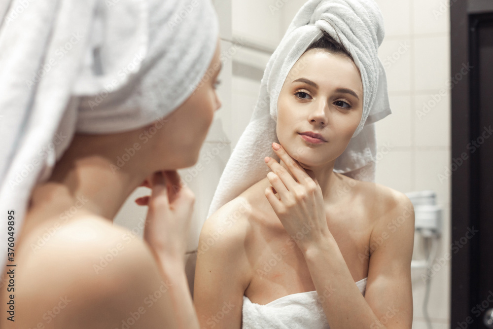 Young woman in bathroom behind mirror Young woman in bathroom behind mirror
