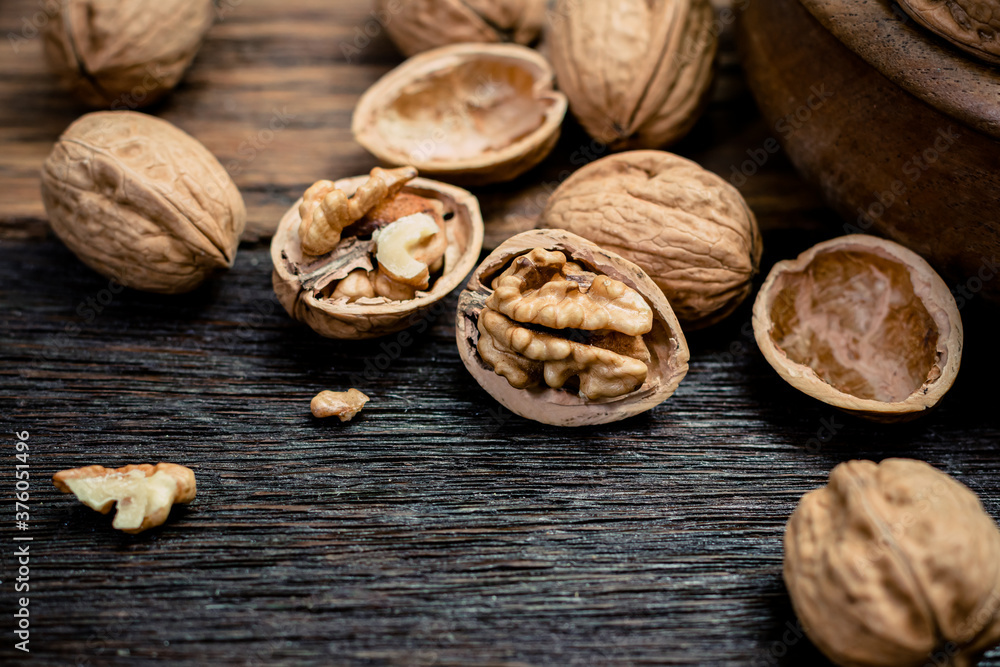 still life with Walnut kernels and whole walnuts on rustic old wooden table still life with Walnut kernels and whole walnuts on rustic old wooden table