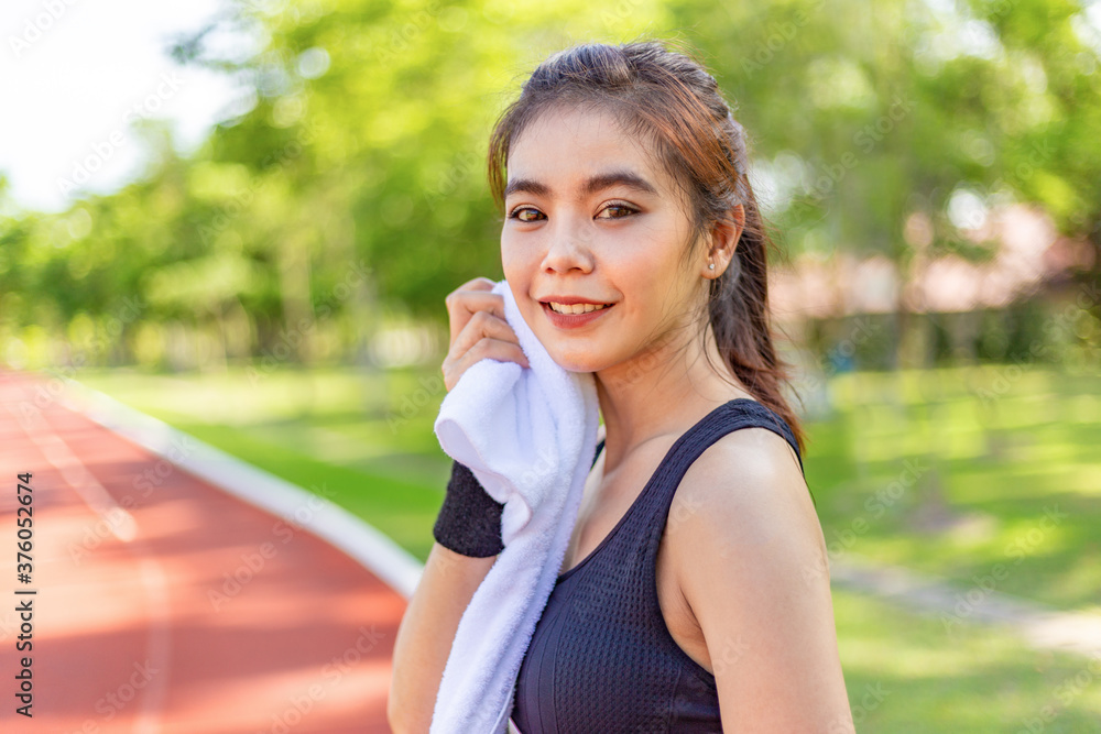Beautiful young Asian woman exercising in the morning at a running track Beautiful young Asian woman exercising in the morning at a running track