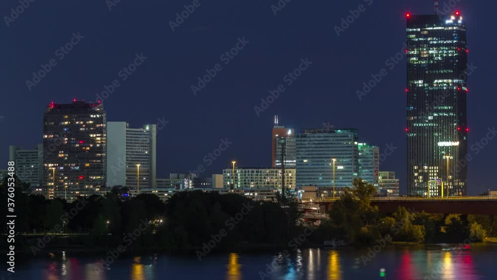 Beautiful cityscape with modern buildings day to night transition timelapse, the tallest skyscraper in Austria reflected in the blue Danube river, in the Donau district of Vienna after sunset. Beautiful cityscape with modern buildings day to night transition timelapse, the tallest skyscraper in Austria reflected in the blue Danube river, in the Donau district of Vienna after sunset.