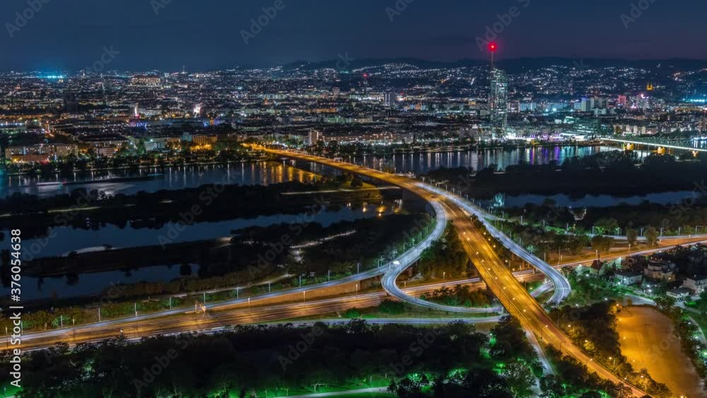 Aerial panoramic view over Vienna city with skyscrapers, highway intersection and a riverside promenade day to night transition timelapse in Austria. Evening skyline after sunset from Danube Tower Aerial panoramic view over Vienna city with skyscrapers, highway intersection and a riverside promenade day to night transition timelapse in Austria. Evening skyline after sunset from Danube Tower
