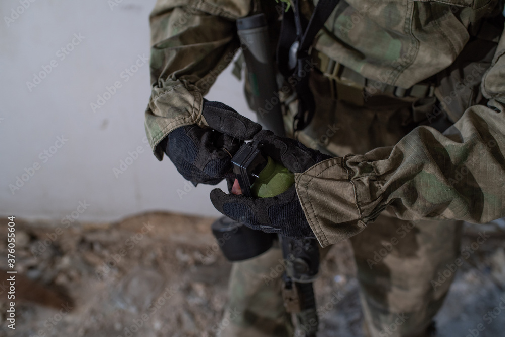 Close-up grenade in the hands of an airsoft player Close-up grenade in the hands of an airsoft player