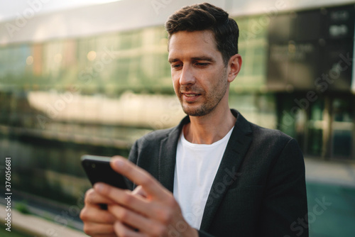 Businessman leader in casual suit using app texting sms message outdoor, Happy confident man messaging with business partner via cellphone, Young Professional Business People