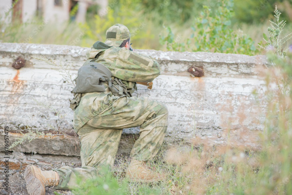 A professional airsoft player aims at his opponents A professional airsoft player aims at his opponents