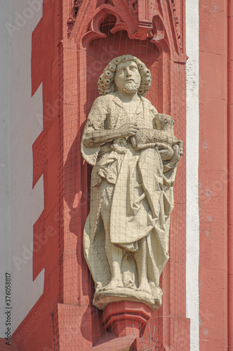 Ancient wall sculpture of a monk at the main facade of Mary chapel in historical downtown of Wurzburg, Germany