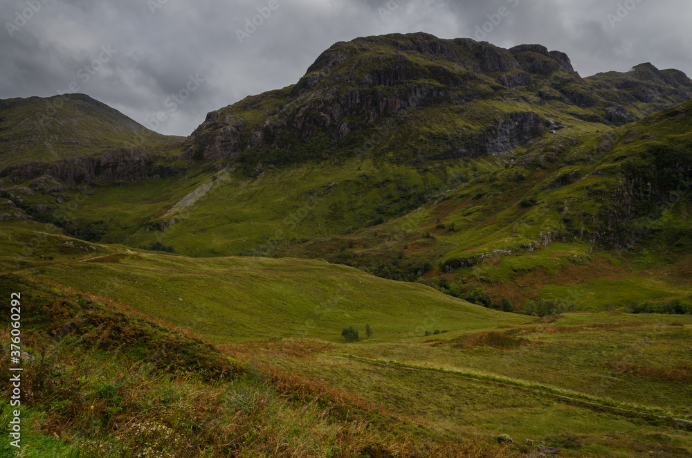 Mountain landscape in the Glen Coe with dark clouds hanging over the peaks, Highland, Scotland