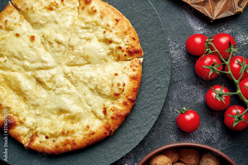 Gruzinsky baked pie with salted cheese - Megrelian khachapuri. Top view photo