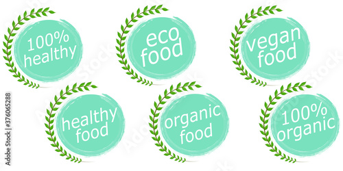 A set of healthy and organic food logos is isolated on a white background. Vector illustration in a flat style. Inscriptions about proper nutrition on mugs with ragged edges, near a tree branch
