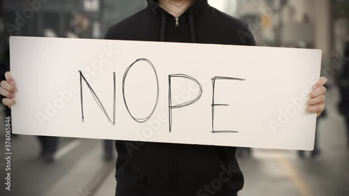 Unknown rioter holds a banner with NOPE text photo