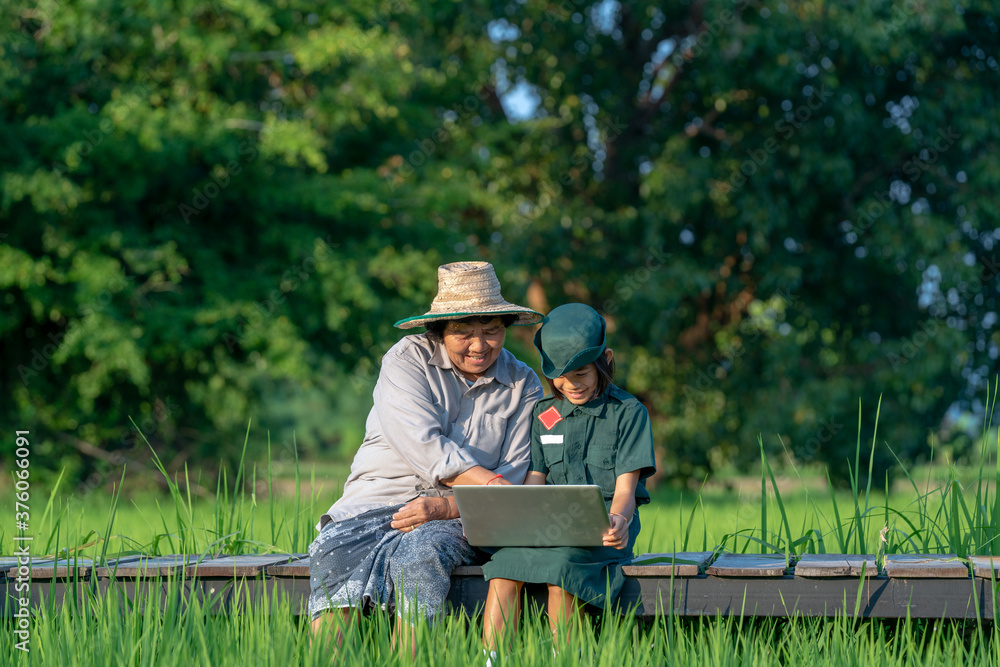 Girl scouts and mother sitting using laptop at countryside. Girl scouts and mother sitting using laptop at countryside.