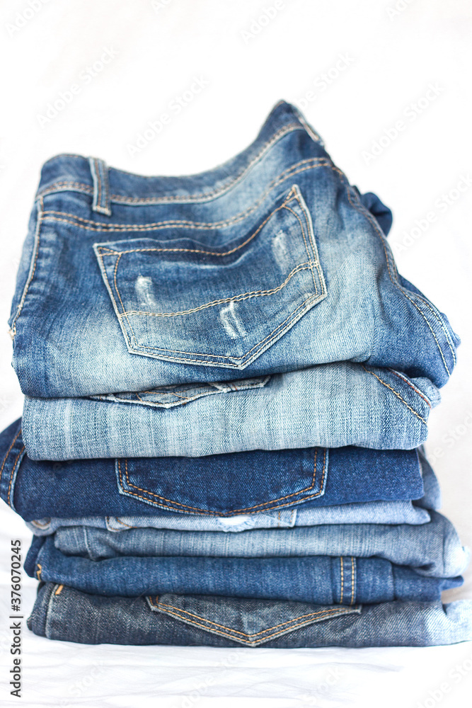 stack of blue jeans of different shades on a white background stack of blue jeans of different shades on a white background