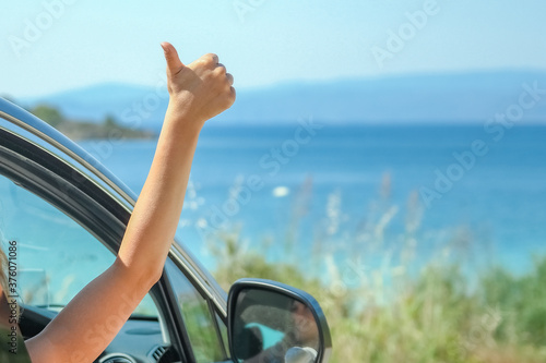 happy girl from car at sea greece background