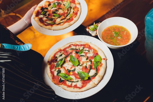 Two pizzas and a bowl of soup in a restaurant