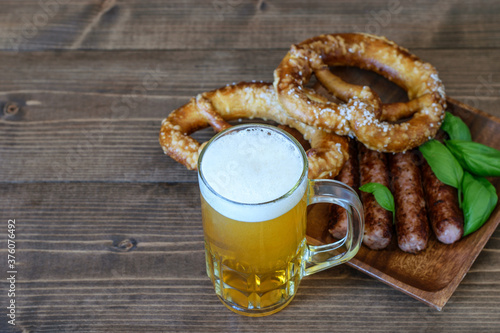 Mug of light beer, fresh pretzels and fried sausages for snack one day of October fest.