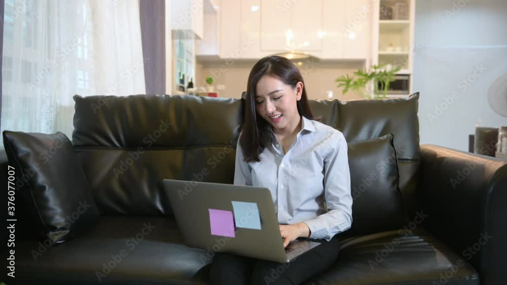 A business woman is working with laptop computer and analyzing business growth graph data in living room, Work from home , business technology concept . A business woman is working with laptop computer and analyzing business growth graph data in living room, Work from home , business technology concept .