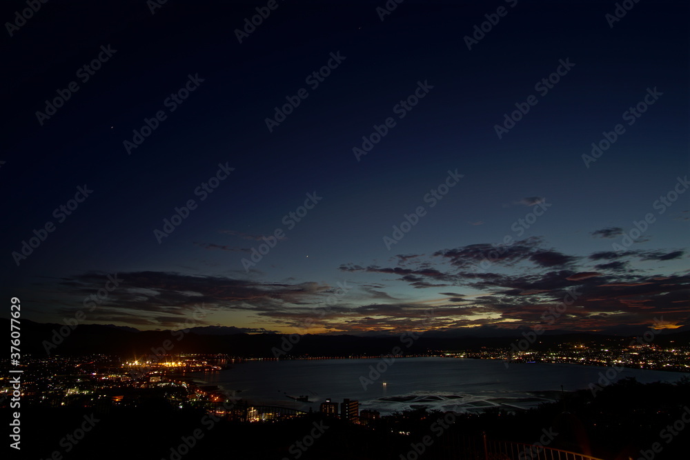 A wide shot looking out over the Lake and the city in Japan during a summer sunset. A wide shot looking out over the Lake and the city in Japan during a summer sunset.
