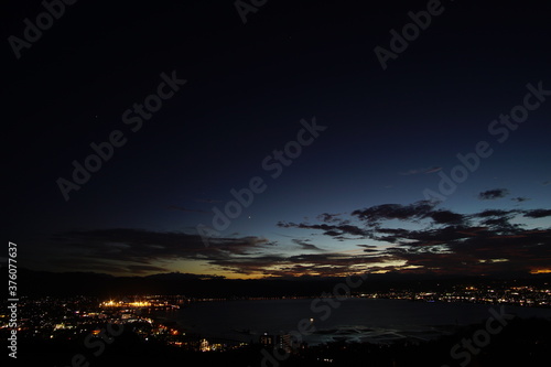 A wide shot looking out over the Lake and the city in Japan during a summer sunset.